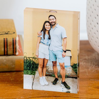 A standup acrylic photo print featuring a couple standing in front of their home. 