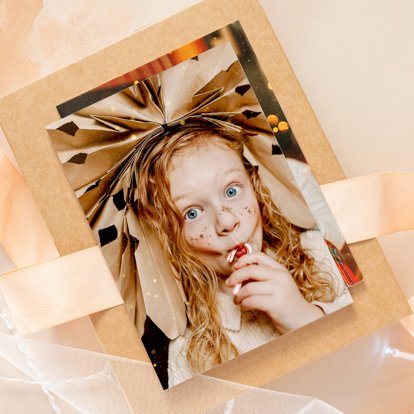 A photo print with a picture of a young girl eating a candy cane.