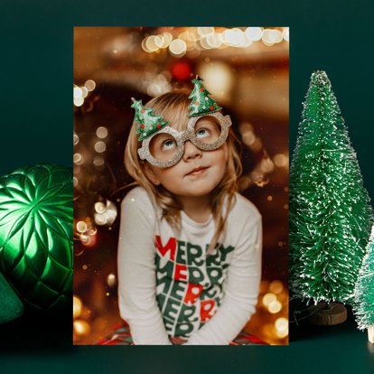 A photo print displayed next to holiday decorations and featuring an image of a child wearing a holiday-themed outfit.