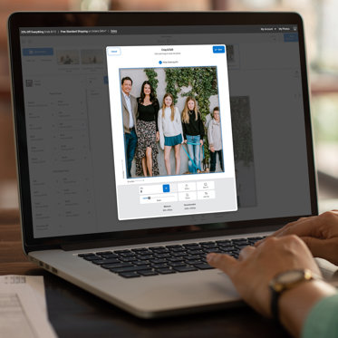 A laptop open to the Mpix website ordering platform. The screen shows a photo being cropped.