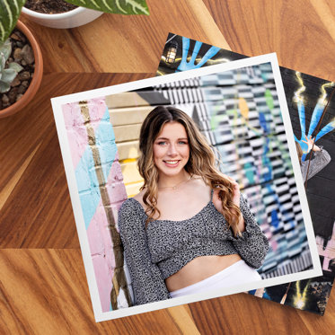 Softcover Photo Book from Mpix sitting on a table with a Large Custom Image Cover featuring a senior photo of an upcoming graduate. 