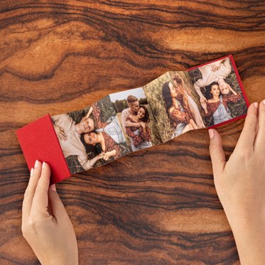 Accordion Mini Photo Book with red linen cover and a collage of photos of a couple on a picnic