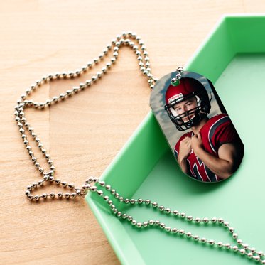 Personalized metal dog tag from Mpix with a sports photo of a high school athlete on a chain.