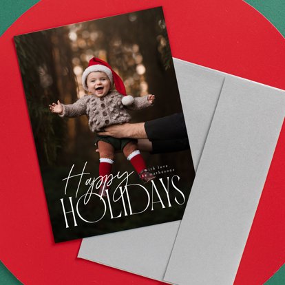 A holiday card with an image of a smiling baby and the headline "Happy Holidays" with personalized text.