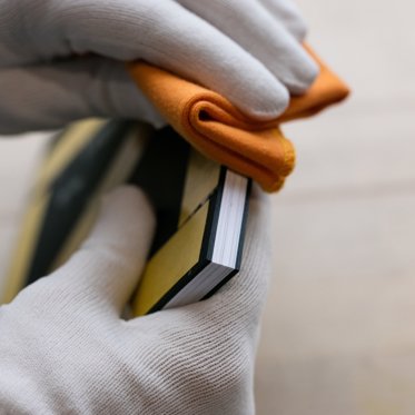 A worker polishes the classic photo book after handcrafting it in our lab.