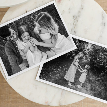 Two Black & White Prints on a table with family photos.