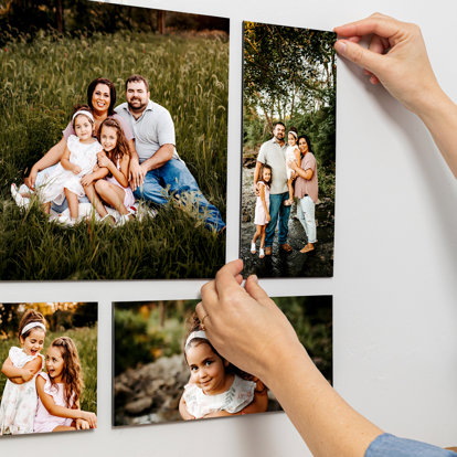 Someone placing the last picture on the wall to complete their Collagewall® display.