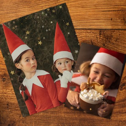 Two photo prints laying on a table and featuring images of children in Christmas outfits.