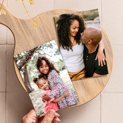 A hand fanning out two 4x6 photo prints from a family photo session.