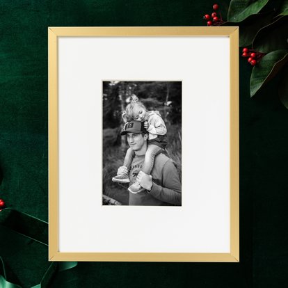A matted and framed print with a black and white photo of a father and daughter.