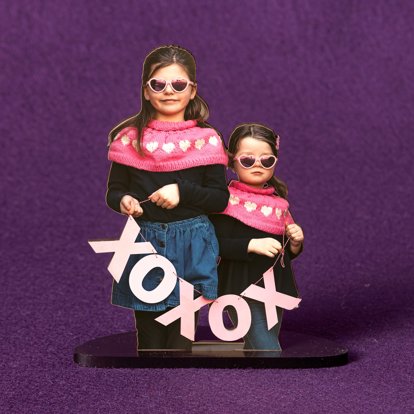 A die-cut statuette in an acrylic holder featuring a Valentine's Day themed photo of two young sisters.