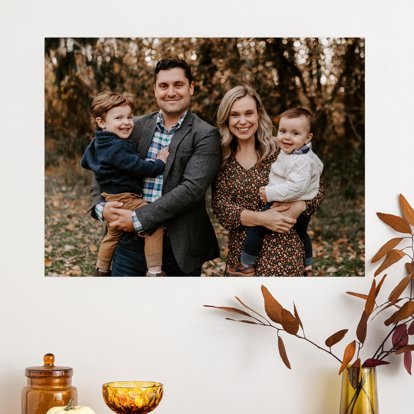 A large metal print displayed on a home wall and featuring an outdoor fall family photo.