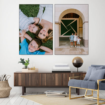 Two framed textile prints hung on a wall in a living room.