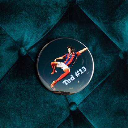Photo button personalized with a sports photo on a dark bluish green velvet background