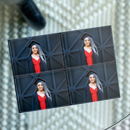 A single sheet of four wallets that have square corners cut featuring grad portraits of a graduating senior in a red dress