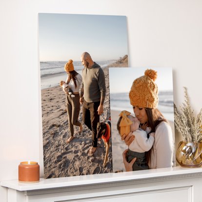 Two Metal Prints featuring family photos on the beach displayed on the mantle of a home.