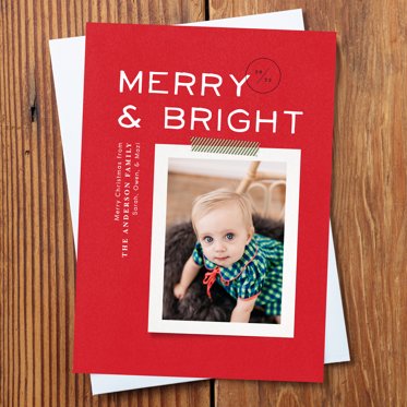 Holiday Photo Card from Mpix with "Merry & Bright" written in white on a red background sitting on a white envelope with room for a personalized photo of your choice. 