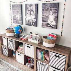 Black-and-white canvas prints of children above a playroom shelf