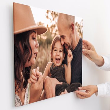 Acrylic photo print from Mpix being mounted to a wall featuring a family playing in a field for family photos. 