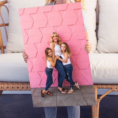 A Metal Print with a family portrait being held. 