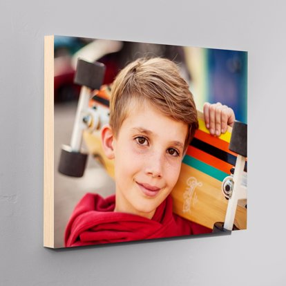 a standout print of a kid holding a skateboard with a wooden edge