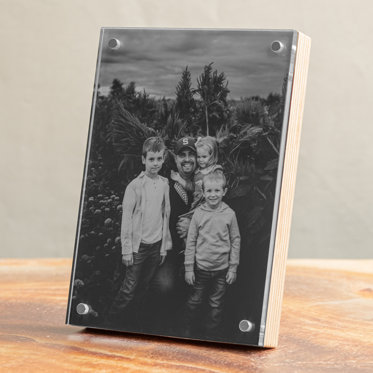 A birch wood photo block from Mpix featuring a print of a family photo in the magnetic frame displayed on a table.