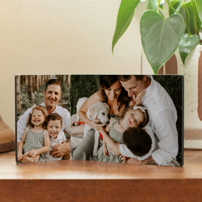 A tabletop hinged print from Mpix featuring two family photos displayed on a table.