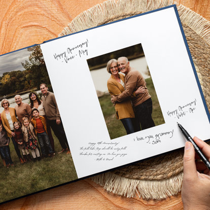 A picture of someone signing a guest book for an anniversary party.