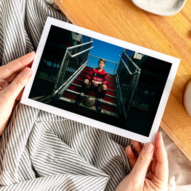 Softcover photo book featuring a large cover photo of an athlete posing in a stadium staircase. 