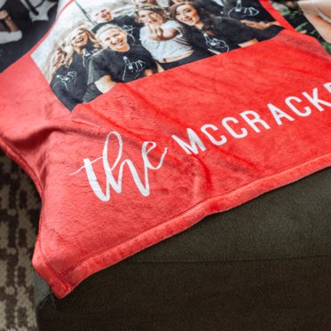 A Personalized Fleece Blanket from Mpix featuring a collage of family photos and a family name. 