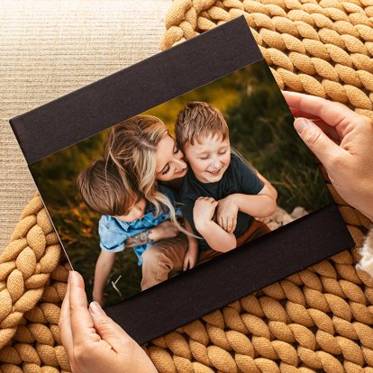 a premium photo book from Mpix featuring a brown linen cover and photographic dust jacket of a mom and her kiddos.