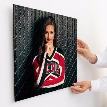 Acrylic print from Mpix being mounted to a wall using it's french cleat mounting system, the photo is of a high school athlete in her cheerleading outfit. 