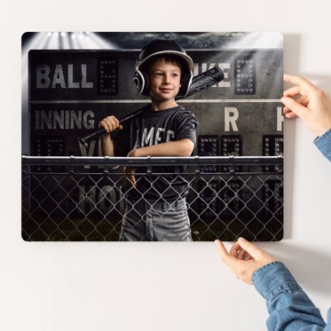Metal photo print from Mpix featuring a tee ball athlete posing by a fence with his bat in his hand. 