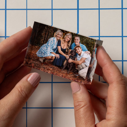 A worker at our lab inspects a mini acrylic block for quality. The mini acrylic block features a a family photo.