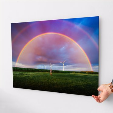 An acrylic print featuring a rainbow hung on a wall.