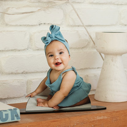 a photo cut out of a young girl wearing a bright blue ribbon placed on a counter