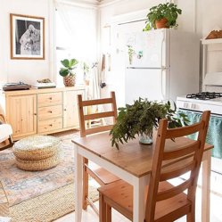 A sunny kitchen and dining nook with a framed print on the wall