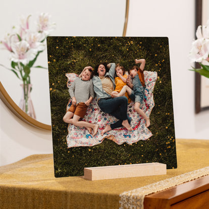 a square tabletop metal print showing a family having a picnic