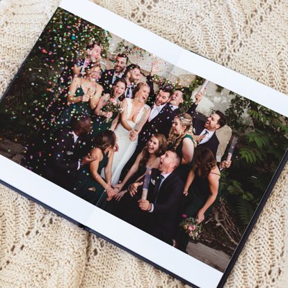 Leather wedding album spread open on a table.