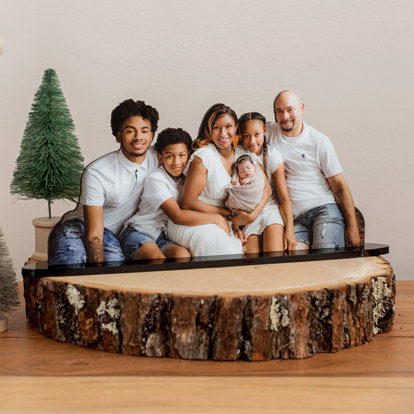 A die cut statuette of a family photo displayed on a table.