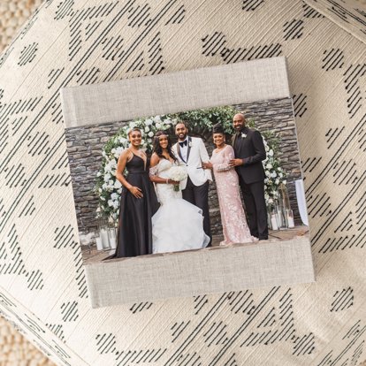 A linen photo book with a sand linen cover and a skinny dust jacket featuring wedding photos.