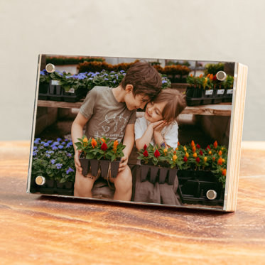 A Photo Print from Mpix featuring an image of a young brother and sister with flowers that is displayed in a Birch Photo Block.