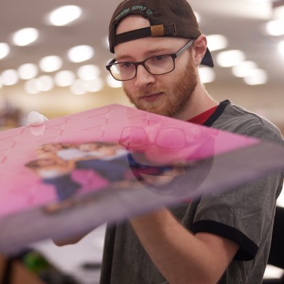 Lab worker inspecting a metal photo print to make sure it meets our high quality standards before sending to a customer. 