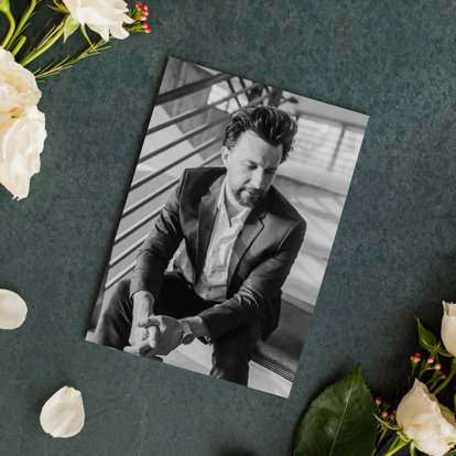 A Black & White Print laying on a table featuring a wedding photo of a groom.