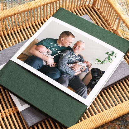 A personalized hardcover photo book with a green linen cover