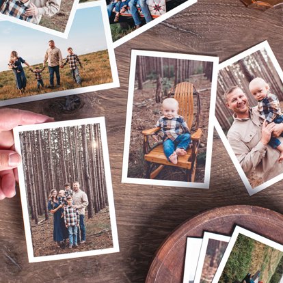 Photos in a Signature Print Set scattered out on a table featuring different images of a young family outside.