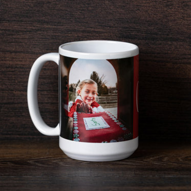 A ceramic photo mug on a table and personalized with a photo of a girl placing her letter to Santa in the mailbox.