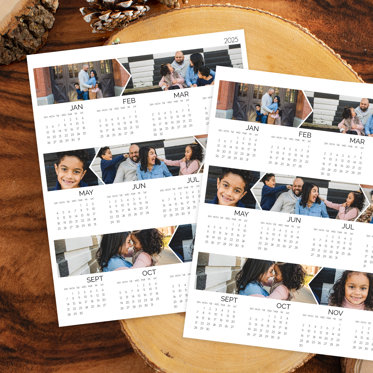 Two single page photo calendars customized with photos laying on a table.