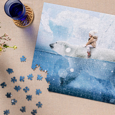 A custom photo puzzle almost fully assembled featuring a child in a coat and hat riding on the back of a polar bear swimming in the water. 