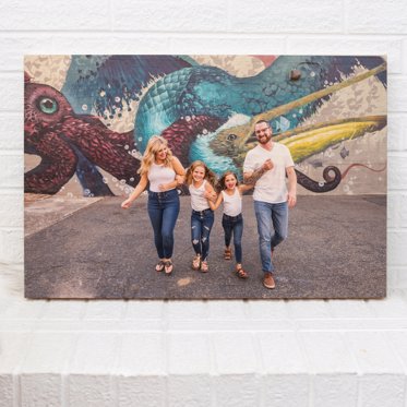 Wood print of a family being shot between buildings in a city.